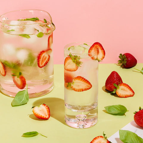 Glass and pitcher of fruit-infused sparkling water